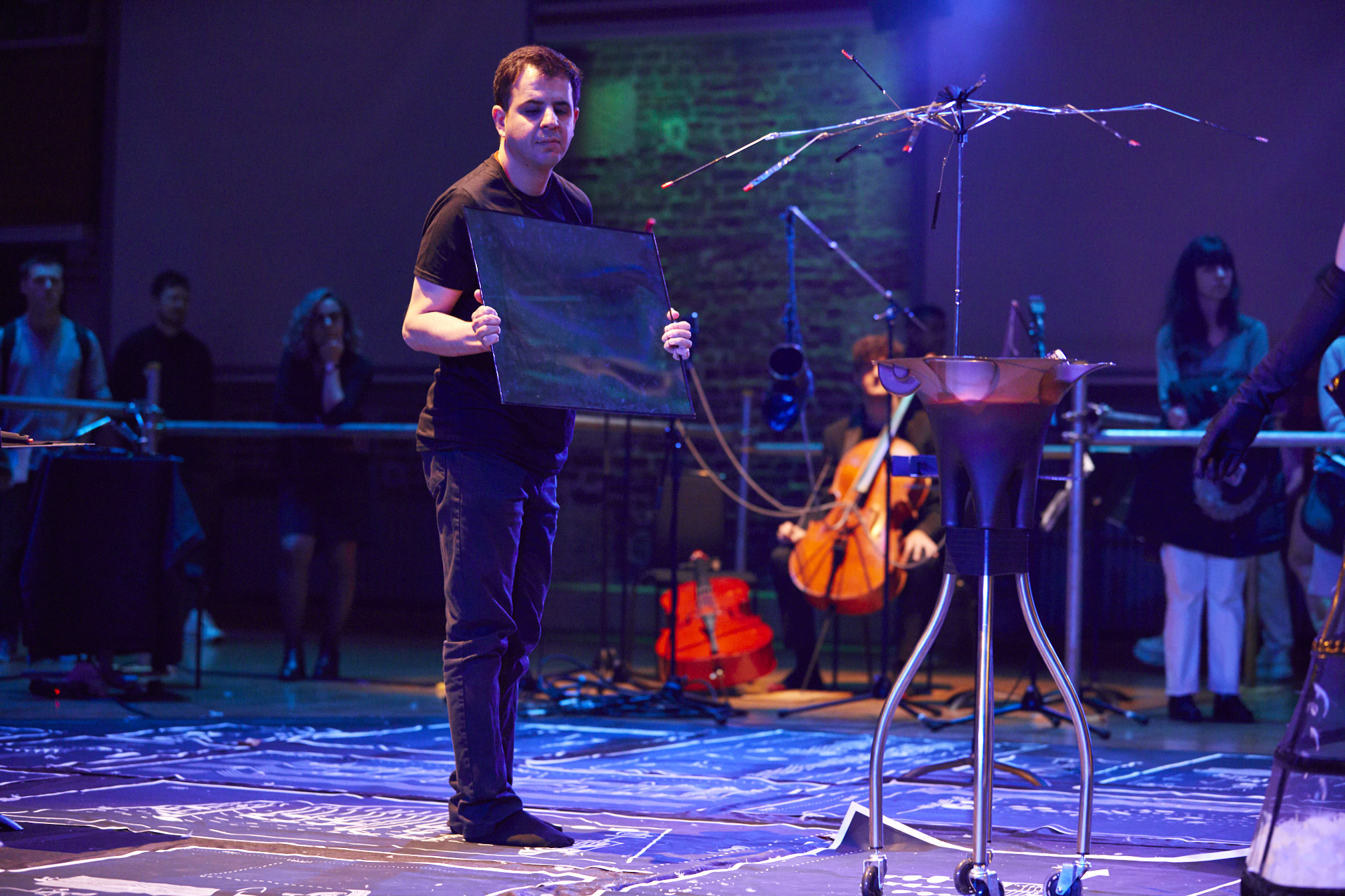 It is a photo of gallery randomly showing Davood standing while holding a mirror in Trinity